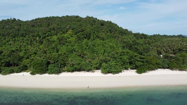 Aerial drone view of quiet beach and romantic couple man and woman walking over the tropical white sand located at Phuket Thailand looks like paradise 4k high resolution footage quality