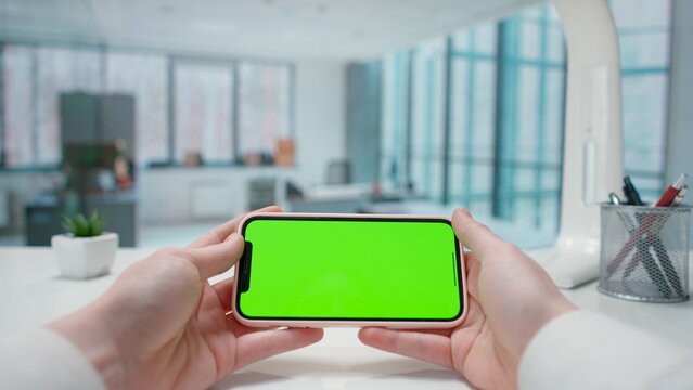 Smartphone with Green Screen on Office Desk. Advertising area, workspace mock up.