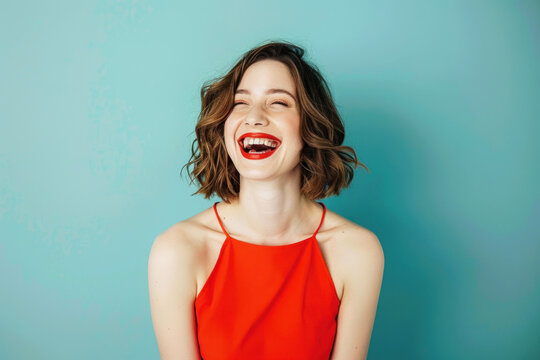 Colorful studio portrait of an attractive young woman laughing happily