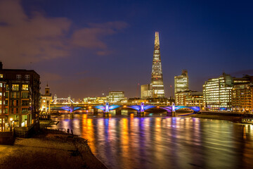 View of London city skyline on colorful sunset, with Southwark bridge over Thames river and the...