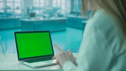 Video Call on Laptop with Green Screen on Research Biochemistry lab Desk. Advertising area, workspace mock up.