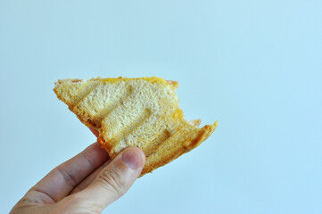 mão segurando lanche alimento pão com presunto 