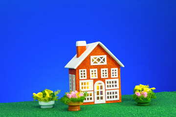 One gray house with flowers around on a blue background