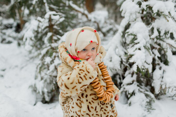 Girl in winter clothes eating bagels
