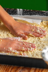 Close up female experienced chef prepares the dough to pizza. Food, the art of cooking and handmade concept. Vertical image.