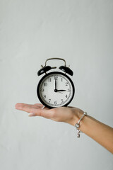 alarm black clock in female hands