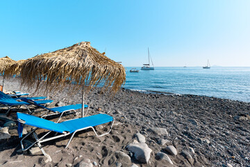 View with beach and boats at the black sand beach of Akrotiri that is known locally as Mesa Pigadia...