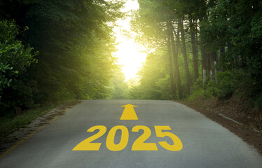 The year 2025 with an arrow on the road. New Year expectations concept with sunrise scene on forest road.