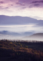 morning landscape with layers of hills and fog in the valley