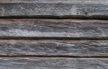 Texture of old weathered gray wall made of hewn logs