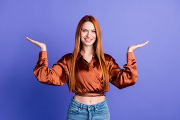 Deurstickers Portrait of nice young woman hands demonstrate empty space wear brown shirt isolated on purple color background © deagreez
