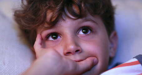 Child close-up of face watching TV screen