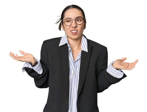 Confident young Caucasian businesswoman on studio background doubting and shrugging shoulders in questioning gesture.