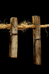 Old wooden clothespins, laundry hooks, on hemp rope, dark background
