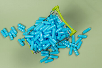blue medicine capsule in miniature shopping cart