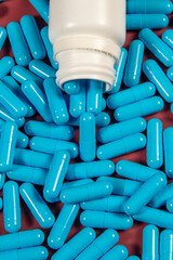 blue medicine capsules and white bottle