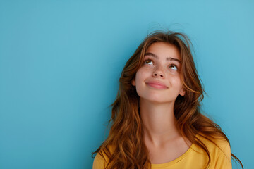 Portrait of attractive curious cheerful brown-haired girl looking up copy empty space clue isolated over bright blue color background - obrazy, fototapety, plakaty
