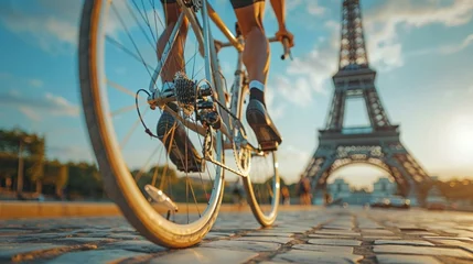 Fotobehang Close-up of bicycle wheels and cyclist, with the Eiffel Tower blurred in the background at sunset © Elen Nika