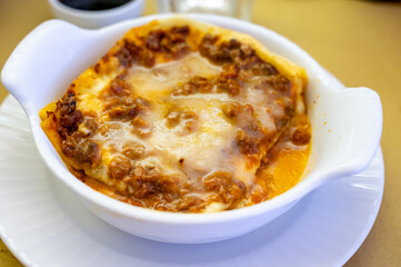 Traditional first course for lunch or dinner in Italy, lasagne Bolognese with beef meat and bechamel sauce served in Italian restaurant, Milan, Italy