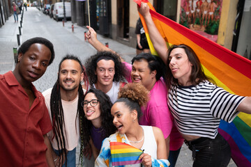 A group of people pose for a selfie, one of them holding a rainbow flag.
one of them holding a rainbow flag.