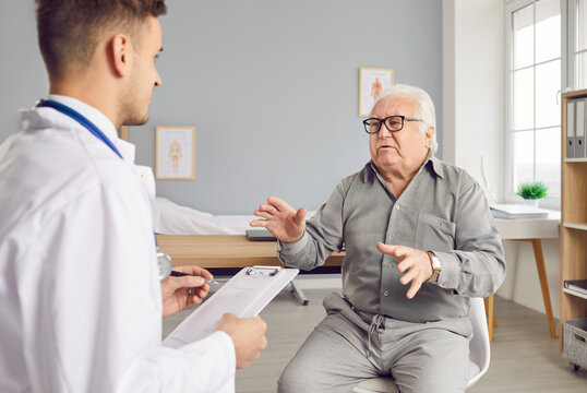 Senior patient man seeks medical care and attention during a hospital consultation. Engaging in a talking with the doctor and nurse, this image reflects the importance of healthcare for the elderly.