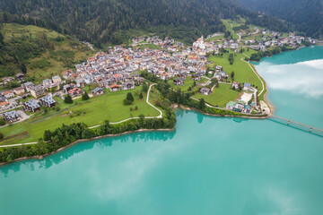 Fototapeta na wymiar Auronzo, Italy - The beautiful turquoise lake and the village of Auronzo in the Dolomite mountains