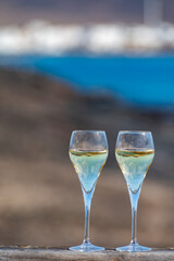 Pouring a glass of champagne on vacation, south of Fuerteventura, Canary islands, blue ocean, mountains