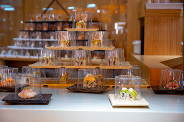 Japanese cuisine, modern restaurant with sushi, sashimi, other Japanese dishes served on moving belt across restaurant, self-service lunch cafe