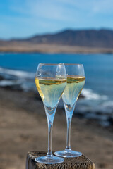 Pouring a glass of champagne on vacation, south of Fuerteventura, Canary islands, blue ocean, mountains