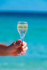 Pouring a glass of champagne on vacation, south of Fuerteventura, Canary islands, blue ocean, mountains