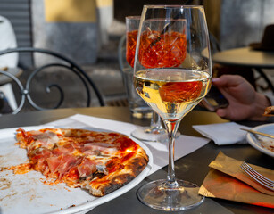 Glass of cold dry white wine served outdoor in cafe in Bellagio, Como lake, Italy