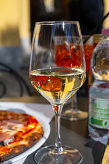 Glass of cold dry white wine served outdoor in cafe in Bellagio, Como lake, Italy