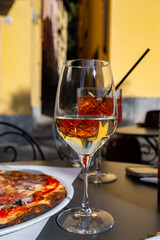 Glass of cold dry white wine served outdoor in cafe in Bellagio, Como lake, Italy