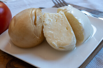 Tasty Italian food, small balls of white and smoked mozzarella soft cheese close up