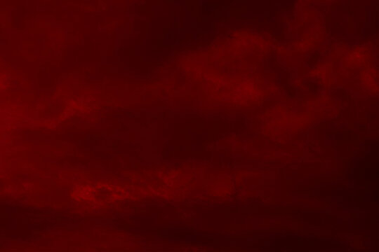 Red cloudy night sky background. Blurred photo of dark red sky. Photo can be used for the concept of galaxy space New Year, Christmas and Halloween backgrounds.	