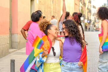 lesbian couple, and a group of people are holding rainbow flags and smiling
