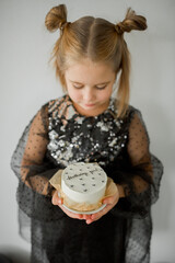 girl in black dress with birthday cake and black balloons 