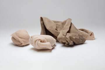 try on nylon socks for fitting shoes, disposable. beige tan, different shades, rolled up into balls. scattered