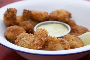 Closeup view of fried breaded shrimps with avocado mayonnaise and lemon.	