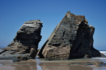 Fototapeta na wymiar Beach of the Cathedrals, Ribadeo - Lugo, Spain, two rocks in the entrance of the beach.