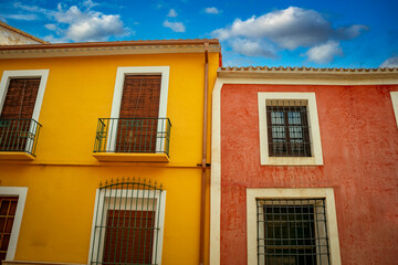 Typical red and yellow colored facades of the old town of Librilla, Region of Murcia, Spain