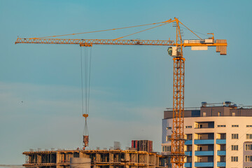 A tower crane delivers concrete to a construction site. Construction of panel high-rise buildings.