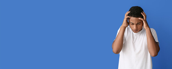 Stressed African-American teenage boy on color background. Stop racism
