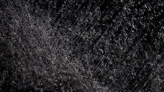 The ice texture is melting. Black and white frosty background.