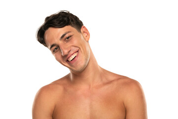 Fototapeta premium Closeup portrait of happy shirtless man 20s looking at camera isolated over white studio background