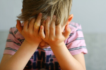 the child is tired or sad, covering his face with his hands.