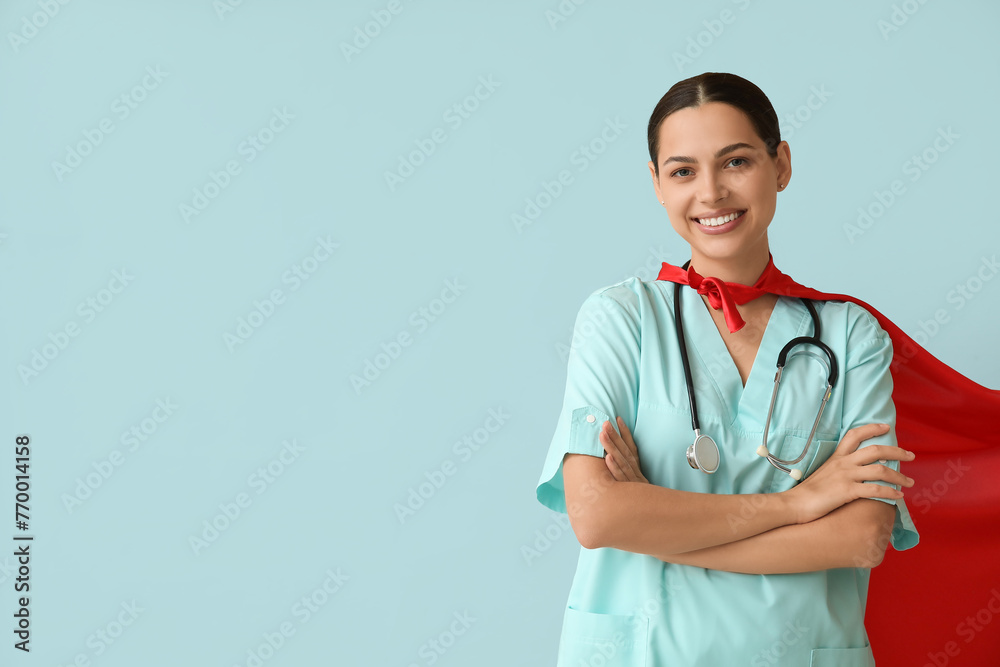 Sticker Beautiful female doctor in superhero costume on blue background