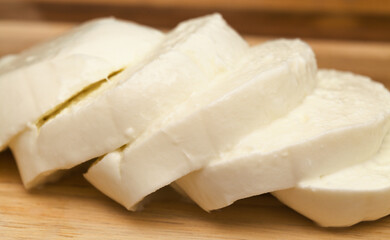 Sliced ball of buffalo mozzarella on a wooden board