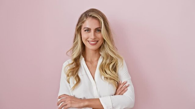 Young blonde woman wearing shirt standing happy face smiling with crossed arms looking at the camera. positive person. over isolated pink background