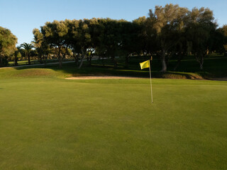 Obraz premium View of golf course with green grass and forest with beautiful putting green with rich green landscape